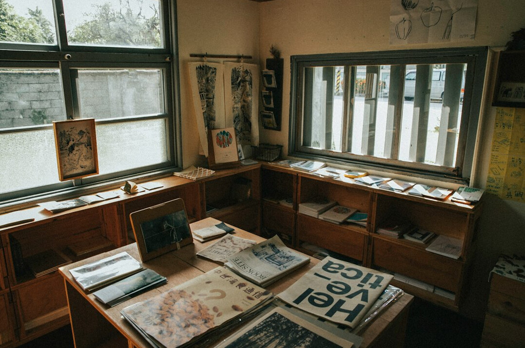 Stacked newspapers and printed research papers on a table