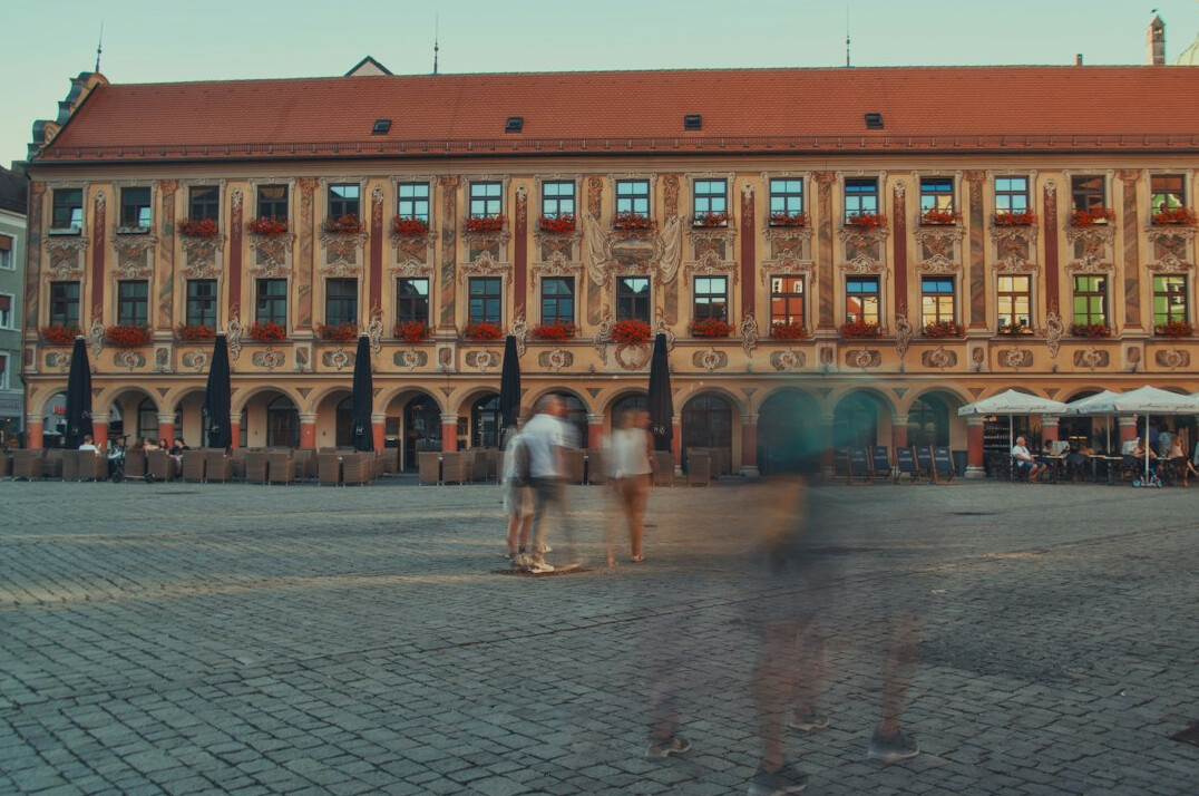 Distant anonymous figures crossing a quiet European city square